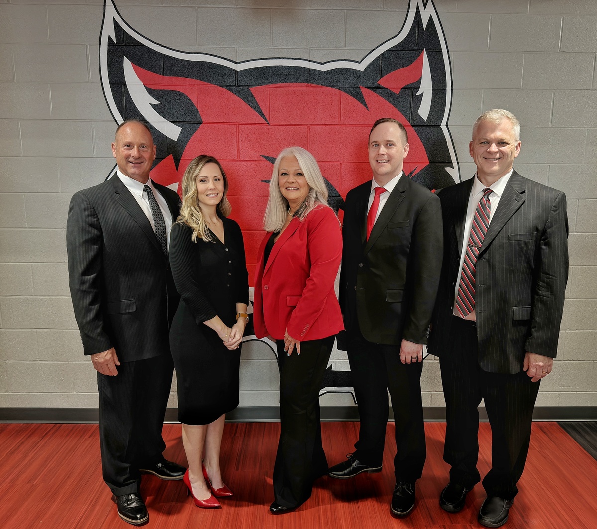 The Franklin Board of Education standing in front of the district's wildcat logo.